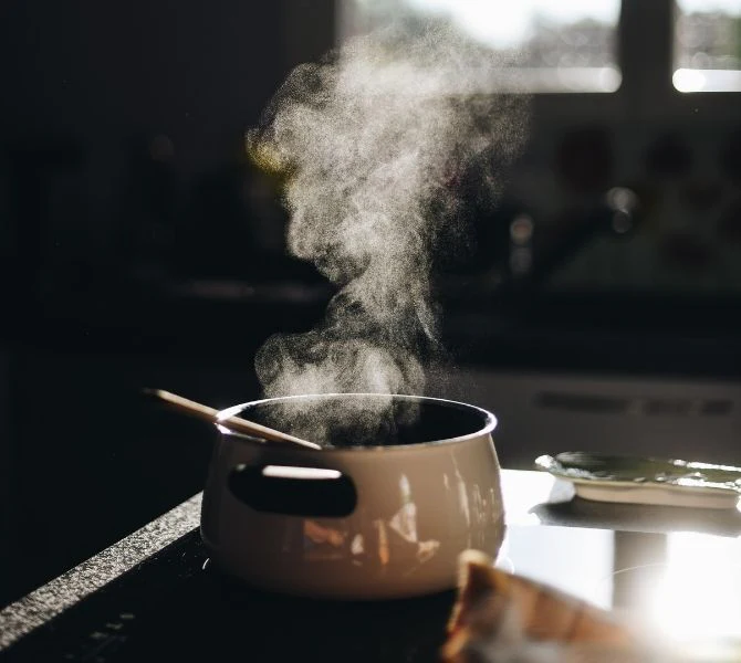 A pot of soup with steam coming out.