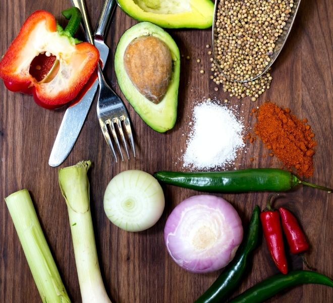 A wooden table topped with lots of different vegetables.